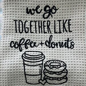 Tan kitchen towel with “we go together like coffee and donuts” design.